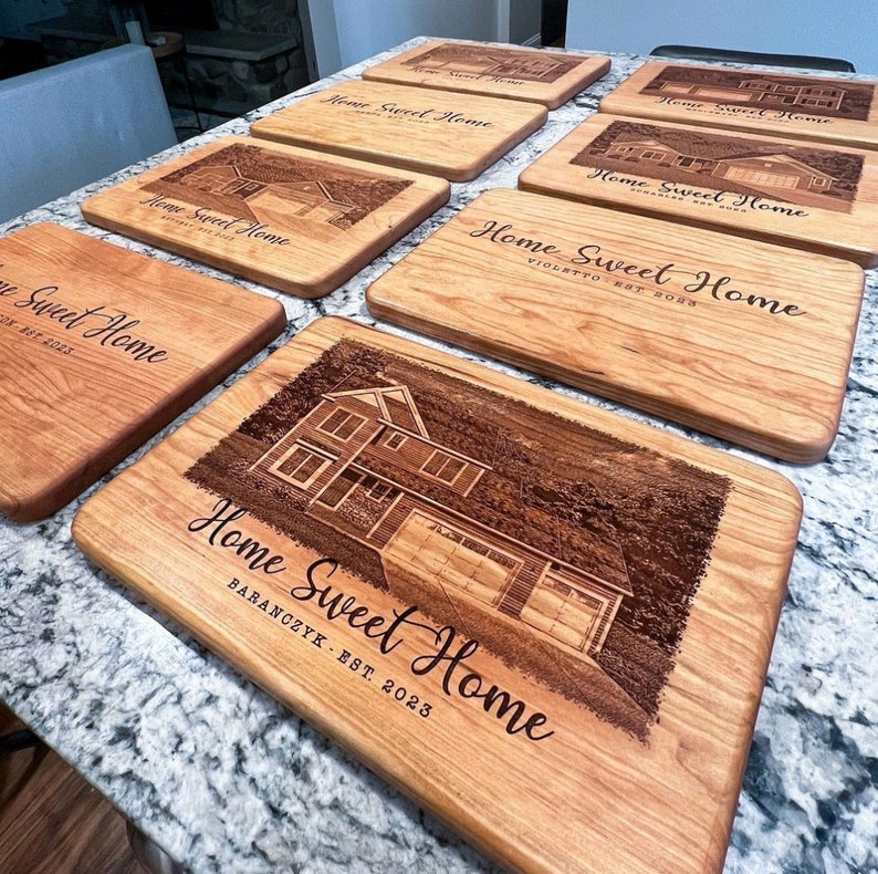 Multiple personalized maple cutting boards engraved with custom house portraits