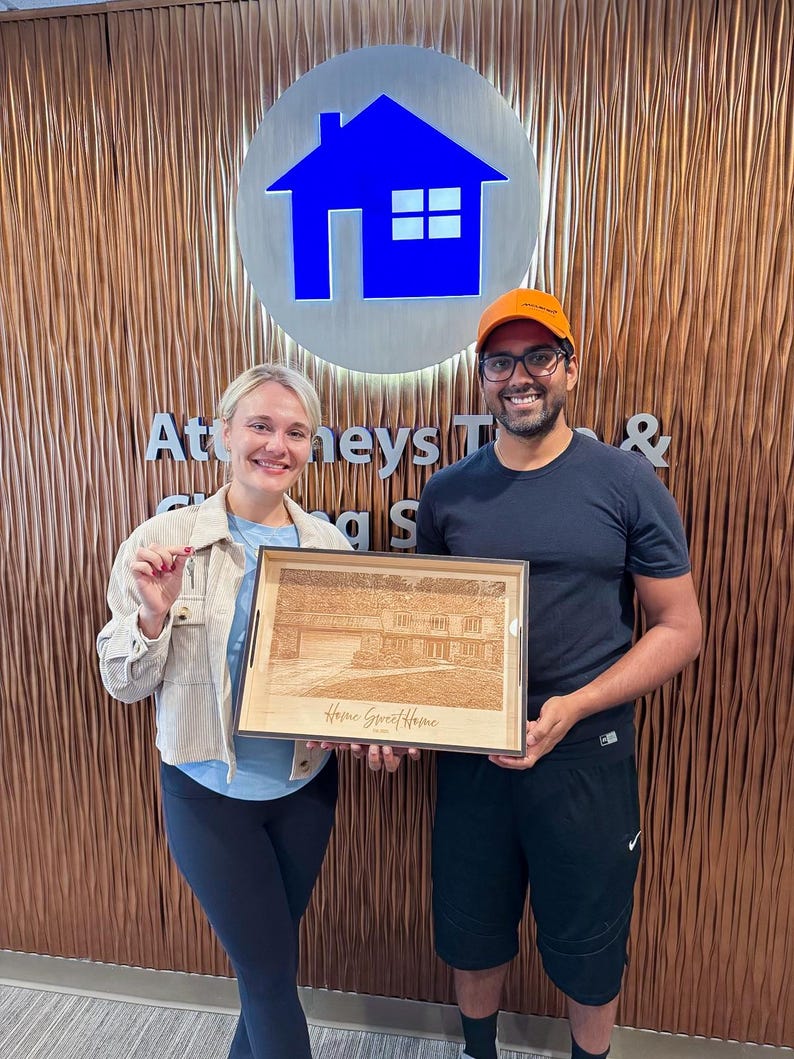 Realtor closing-gift recipients holding a personalized engraved ottoman tray